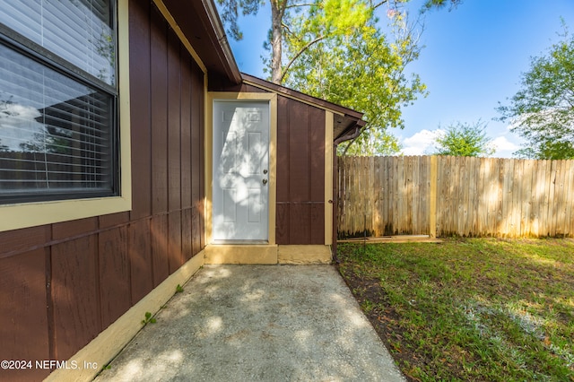 view of exterior entry featuring a lawn