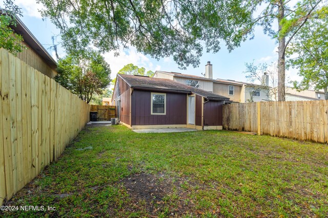 back of house with a patio and a yard