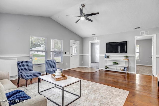 living room with ceiling fan, hardwood / wood-style flooring, and vaulted ceiling