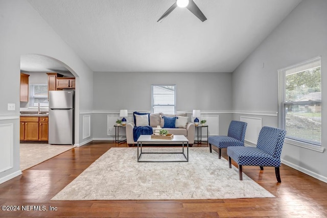 living area featuring hardwood / wood-style flooring, plenty of natural light, and vaulted ceiling