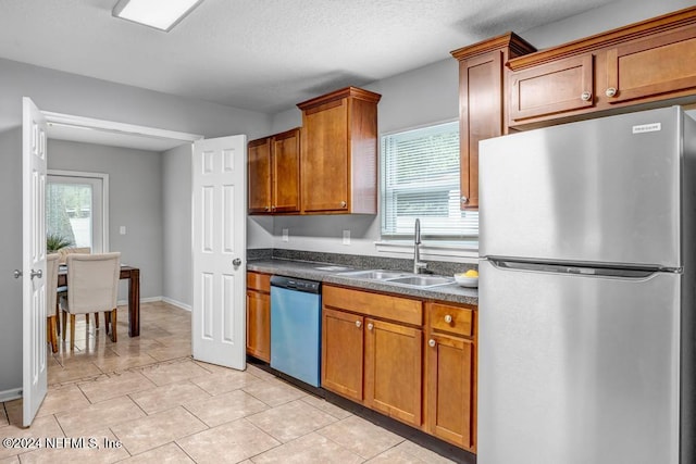 kitchen with a wealth of natural light, sink, appliances with stainless steel finishes, and a textured ceiling