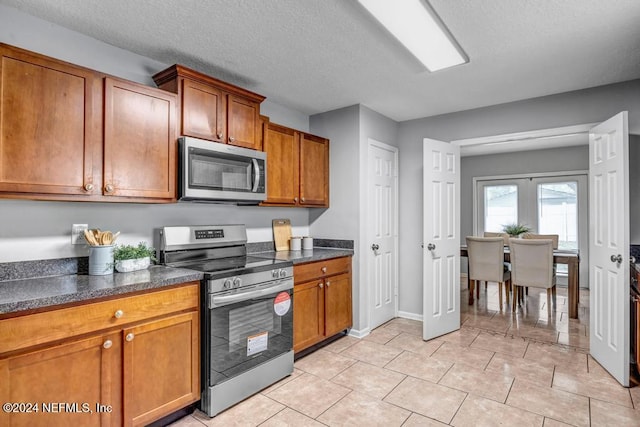 kitchen featuring appliances with stainless steel finishes, french doors, and a textured ceiling