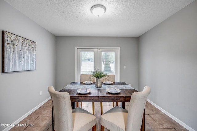 tiled dining space featuring a textured ceiling