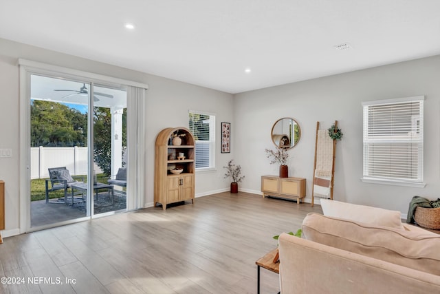 living room with ceiling fan and light hardwood / wood-style flooring