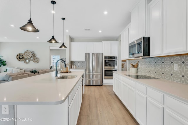 kitchen featuring stainless steel appliances, sink, a center island with sink, light hardwood / wood-style flooring, and white cabinetry