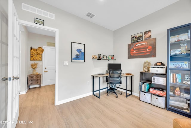 home office with light hardwood / wood-style flooring