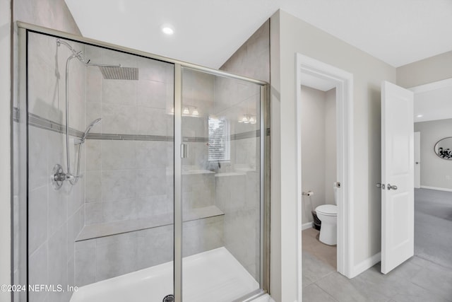 bathroom featuring toilet, tile patterned floors, and walk in shower