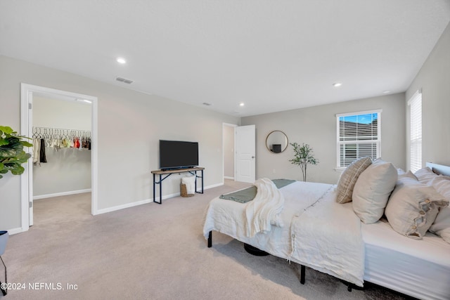 carpeted bedroom featuring a spacious closet and a closet