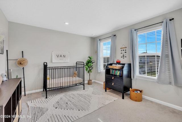 carpeted bedroom with a nursery area