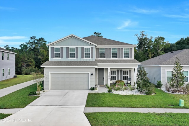 view of front of home featuring a porch, a front yard, and a garage