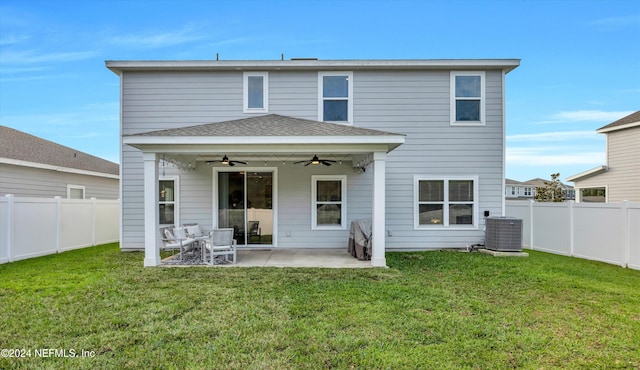 rear view of property featuring central AC unit, a yard, and a patio