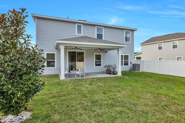 rear view of house featuring central air condition unit, ceiling fan, a patio area, and a lawn