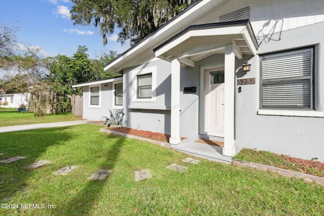 doorway to property with a lawn