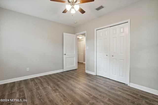 unfurnished bedroom with ceiling fan, dark hardwood / wood-style floors, and a closet