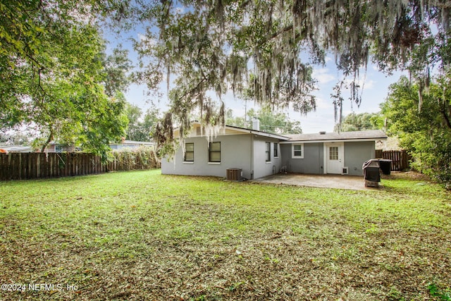 back of property featuring central air condition unit, a patio, and a yard