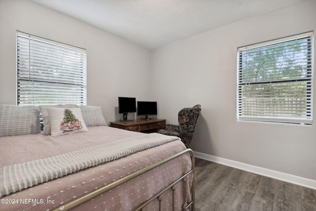 bedroom with dark wood-type flooring, multiple windows, and a textured ceiling