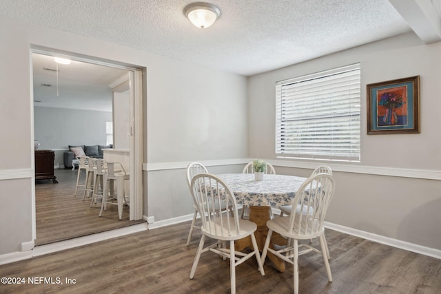 dining space with wood-type flooring and a textured ceiling