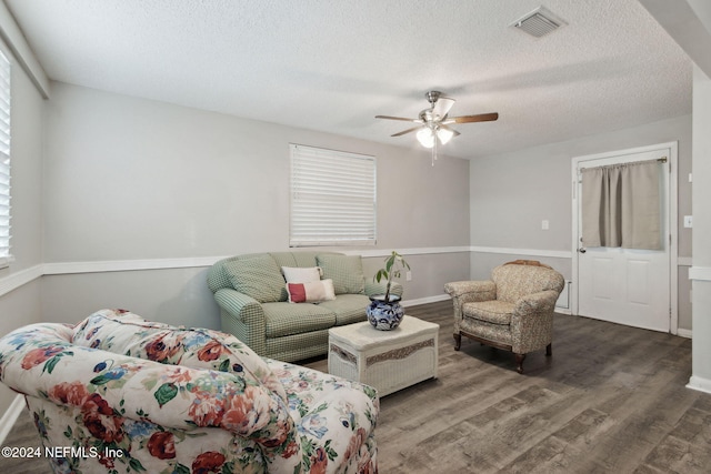 living room featuring ceiling fan, a wealth of natural light, wood-type flooring, and a textured ceiling