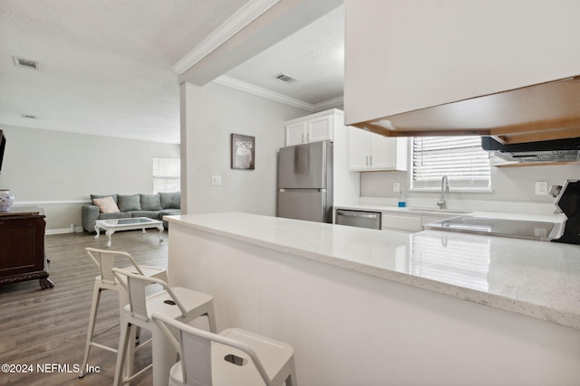 kitchen featuring light stone counters, hardwood / wood-style floors, sink, white cabinetry, and appliances with stainless steel finishes