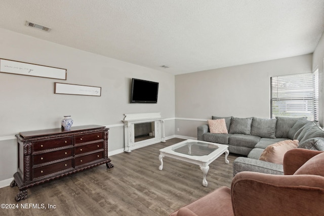 living room with hardwood / wood-style floors, a fireplace, and a textured ceiling