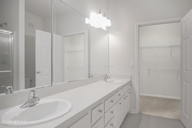 bathroom with vanity, tile patterned floors, an enclosed shower, and toilet