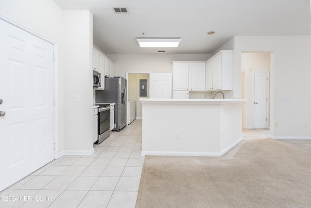 kitchen featuring white cabinetry, stainless steel appliances, and light carpet