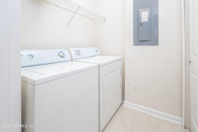 clothes washing area with washer and clothes dryer, electric panel, and light tile patterned floors