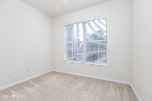 unfurnished room featuring ceiling fan and carpet flooring