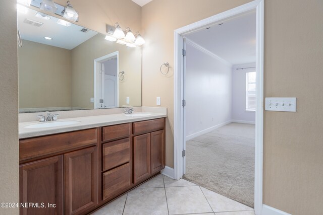 bathroom with tile patterned flooring, crown molding, and vanity