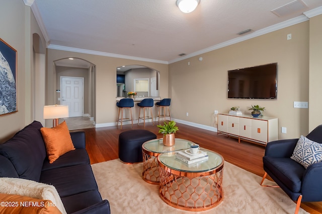 living room featuring hardwood / wood-style floors and crown molding