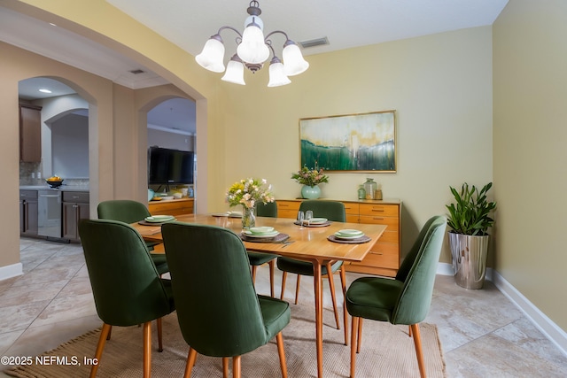 tiled dining space with an inviting chandelier and ornamental molding