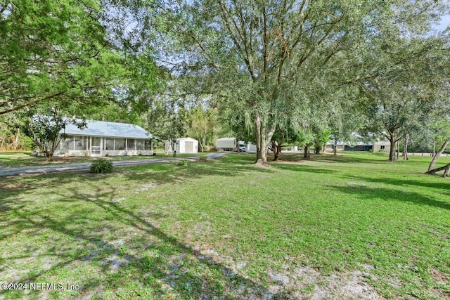 view of yard with a sunroom and a shed