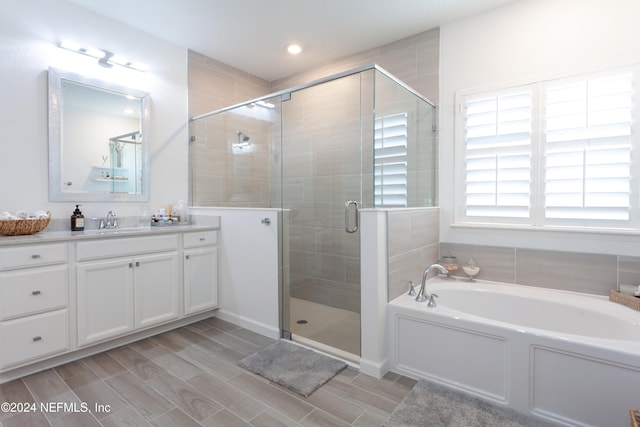 bathroom with vanity and separate shower and tub