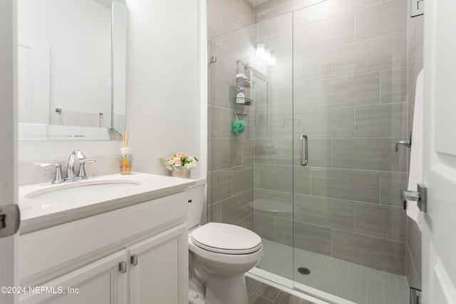 bathroom with vanity, toilet, and an enclosed shower