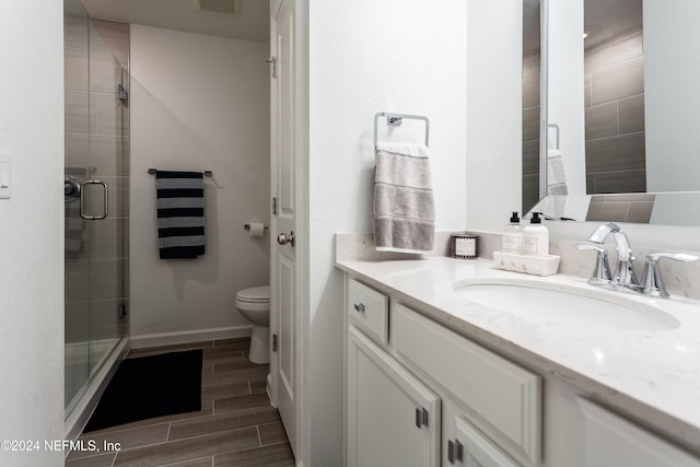 bathroom with toilet, vanity, and walk in shower