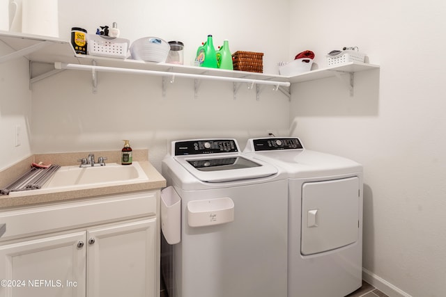 laundry area featuring cabinets, independent washer and dryer, and sink