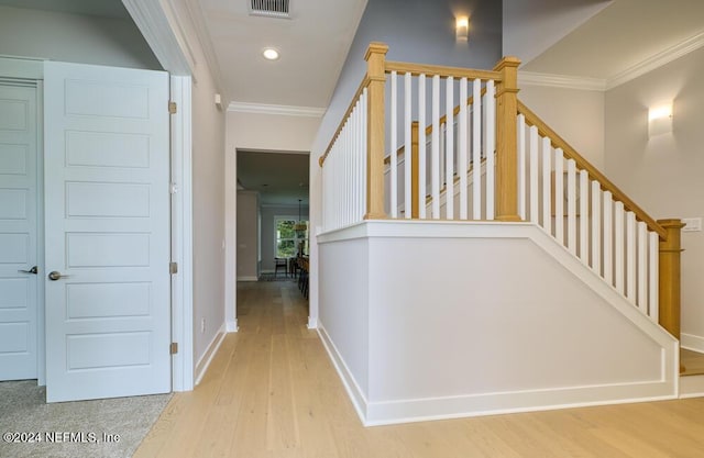 hallway with crown molding and light wood-type flooring