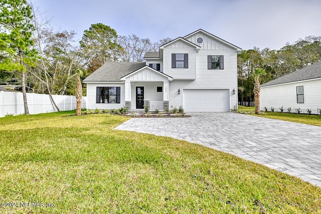 view of front facade featuring a front yard, a garage, and covered porch