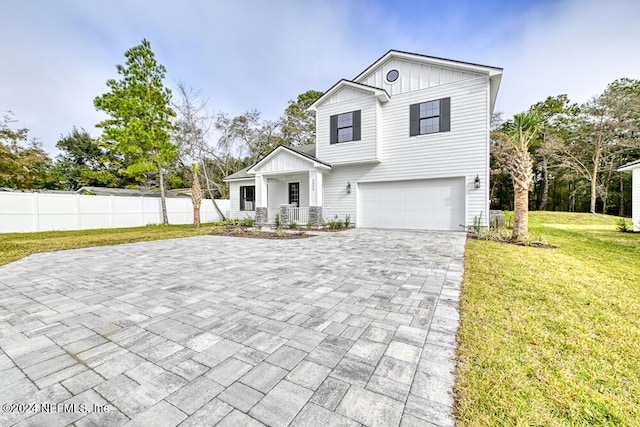 view of front of house with a porch, a garage, and a front lawn