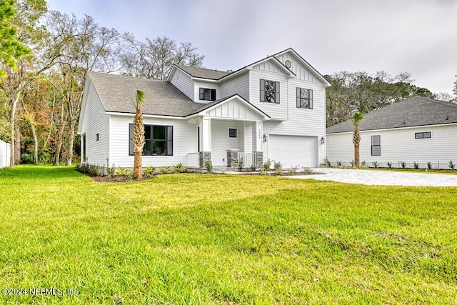 view of front of home featuring a porch, a garage, and a front lawn