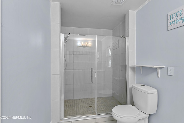 bathroom with toilet and a shower with shower door