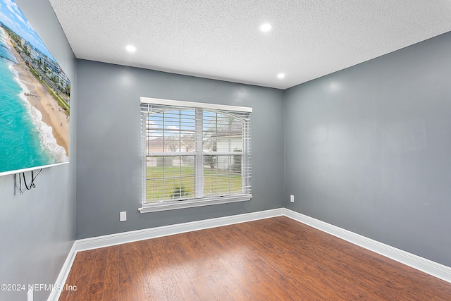 spare room with wood-type flooring and a textured ceiling