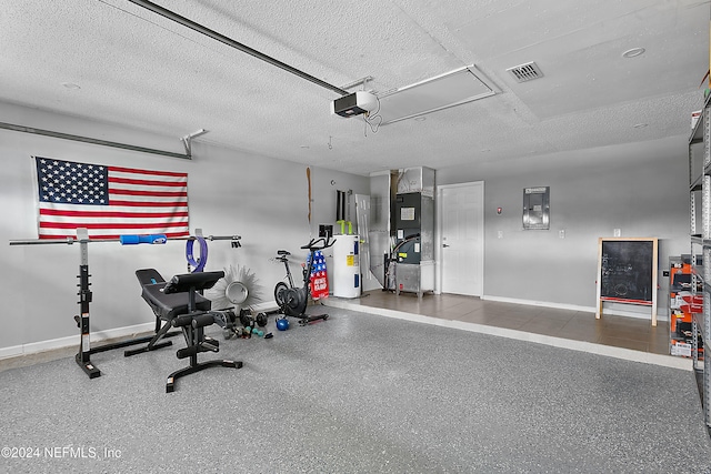 exercise area featuring electric water heater, a textured ceiling, and heating unit