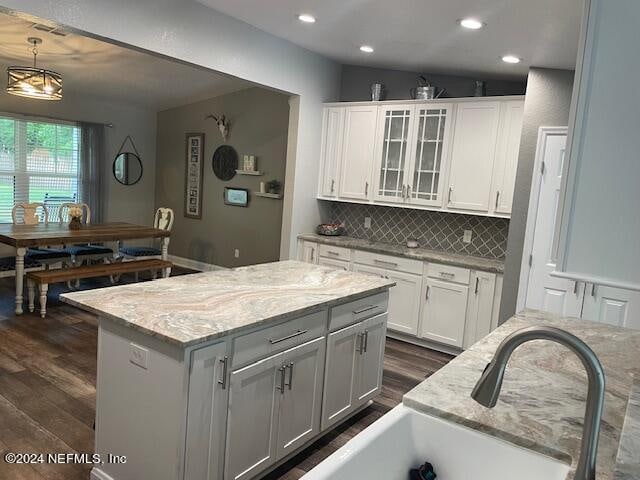 kitchen featuring pendant lighting, a center island, dark hardwood / wood-style floors, and white cabinets