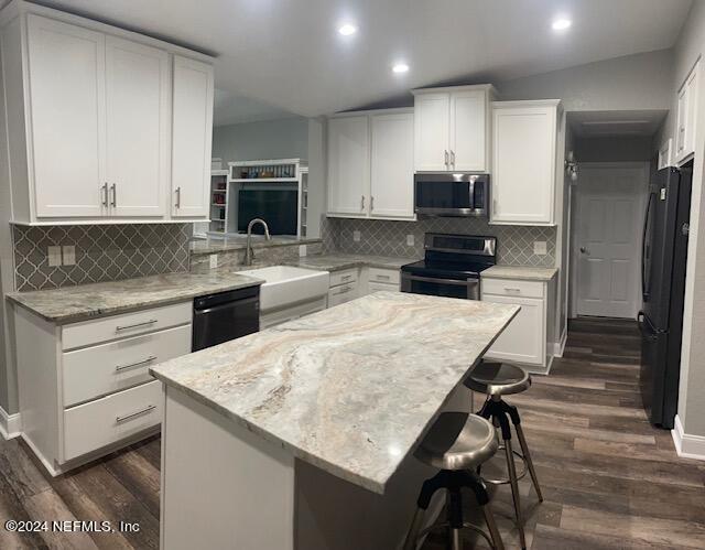 kitchen featuring black appliances, dark hardwood / wood-style flooring, white cabinetry, vaulted ceiling, and decorative backsplash