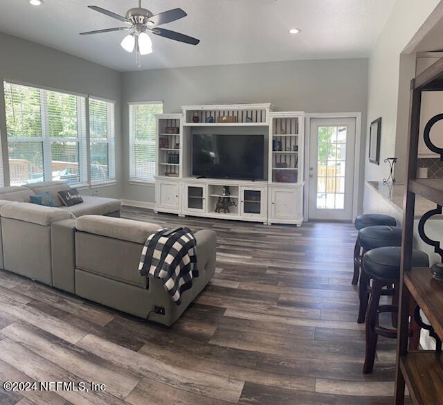 living room featuring ceiling fan and dark hardwood / wood-style flooring