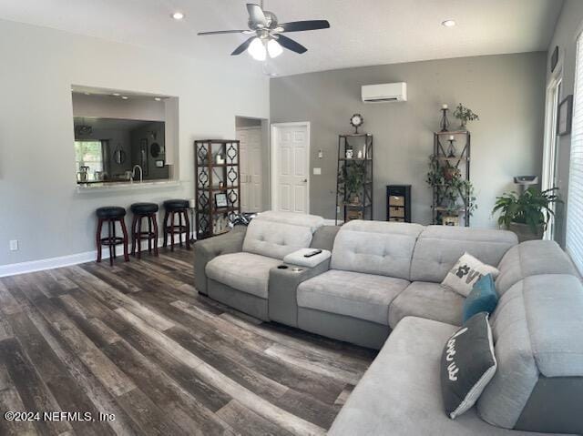 living room featuring an AC wall unit, dark wood-type flooring, and ceiling fan