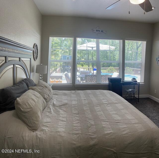 bedroom with multiple windows, carpet floors, and ceiling fan