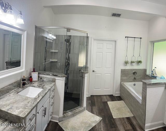 bathroom featuring vanity, hardwood / wood-style floors, and independent shower and bath