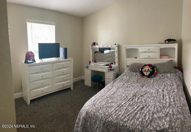 bedroom featuring dark carpet